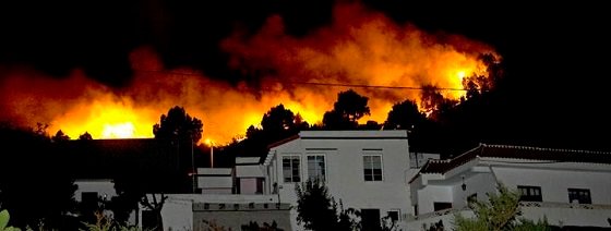 A forest fire approaches homes as it burns out of control in Fuencaliente municipality on the southern part of La Palma island in Spain's Canary Islands early August 2, 2009. Up to 4,000 people have been evacuated from the southern part of the island, according to authorities.  REUTERS/Santiago Ferrero  (SPAIN DISASTER)